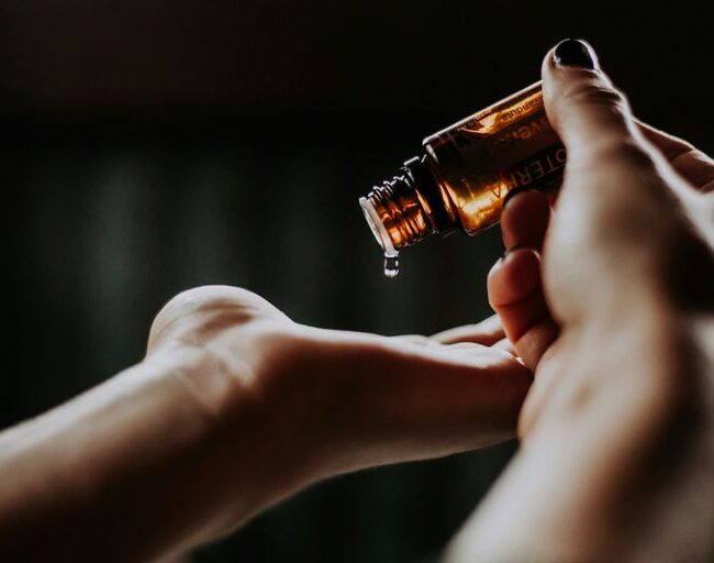 person holding amber glass bottle