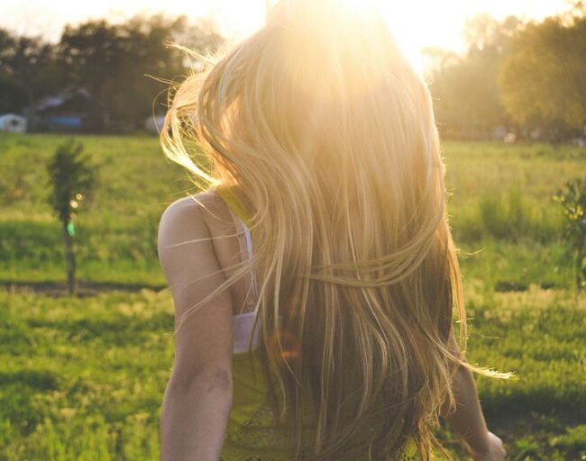 woman walking on lawn with trees