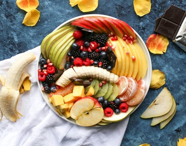bowl of sliced fruits on white textile